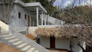 a white house with stairs and a straw roof at Lalito in Zipolite