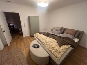 een slaapkamer met een groot bed en een poef bij Saar-Lor-Lux-Perle in Merzig +93 foto's