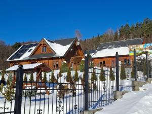 a house with solar panels on the roof in the snow at Dom u Julii Bieszczady in Ustrzyki Dolne