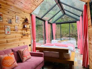 a room with a bed and a couch and a window at Eça River Bungalov in Ayder Yaylasi