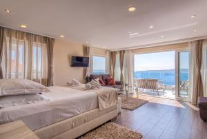 a bedroom with a large bed and a balcony at Villa Višnja Prestige in Brela +130 photos