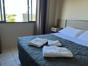 a hotel room with two towels on a bed at Hotel Ermitage in Santana do Livramento +57 photos