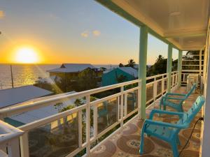 two chairs on a porch watching the sunset at Posada Three Cay Suites in Providencia