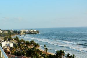 vistas a una playa con palmeras y al océano en Colombo Mount Beach en Mount Lavinia