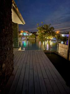 a wooden deck with a view of the water at night at Mermaid Waterways in Whitianga