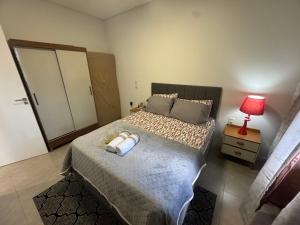 a bedroom with a bed with a red lamp on a table at Casa Nova & Aconchegante in São Bento do Sul