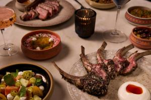 a table with plates of food and glasses of wine at Kimpton La Peer West Hollywood by IHG in Los Angeles +141 photos