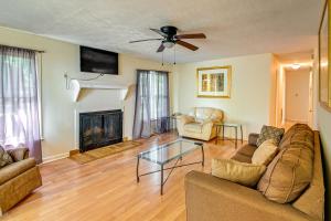 een woonkamer met een bank en een open haard bij Fayetteville Vacation Rental with Yard! in Fort Bragg