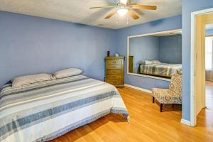 een slaapkamer met een bed, een spiegel en een stoel bij Fayetteville Vacation Rental with Yard! in Fort Bragg