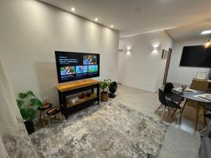 a living room with a flat screen tv on a wall at Casa Nova & Aconchegante in São Bento do Sul