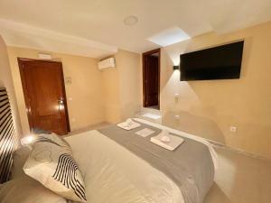 a hotel room with a bed and a flat screen tv at Júbilus Rooms in Toledo +26 photos