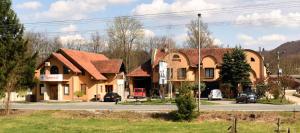 a house on a street with cars parked in front at Smestaj SIMOVIC 1 in Arilje