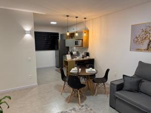 a living room with a couch and a table and chairs at Casa Nova & Aconchegante in São Bento do Sul