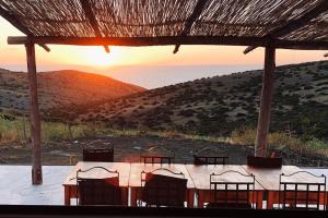 a group of chairs sitting around a table with the sunset at Dar-west in Demina