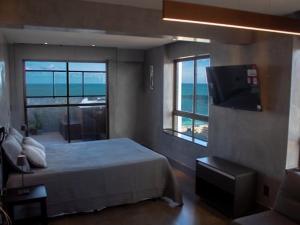 a bedroom with a bed and a view of the ocean at Cobertura vista mar in Natal +13 photos