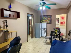 a living room with a ceiling fan and a table and chairs at Merendon Suite Apartamento in San Pedro Sula
