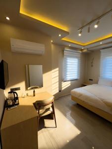 a bedroom with a bed and a desk with a television at InOut Social in Fethiye +34 photos