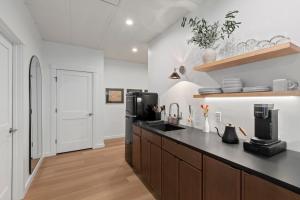 a kitchen with a black counter and a refrigerator at The Optimist Guesthouse | 5 in Camden