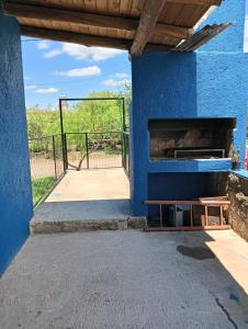a blue building with a fireplace and a gate at Los Talitas in Villa Parque Siquiman