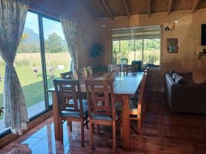 a dining room with a table and chairs and a couch at Casa Entre Cerros in Futrono