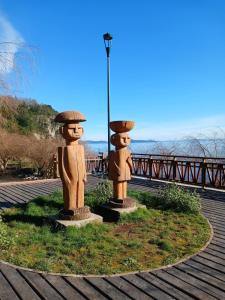 two statues sitting on the side of a road at Casa Entre Cerros in Futrono +6 photos