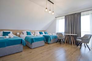 a bedroom with two beds and a table and chairs at Agroturystyka U Sadzy in Krajno Pierwsze