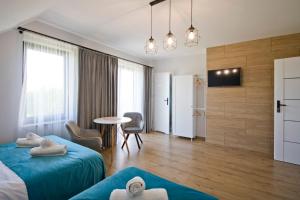 a hotel room with two beds and a table at Agroturystyka U Sadzy in Krajno Pierwsze