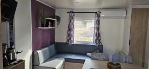a small living room with a couch and a window at Bienvenue au Cap Ferret in Lège-Cap-Ferret