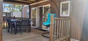 a patio with a table and chairs on a deck at Bienvenue au Cap Ferret in Lège-Cap-Ferret