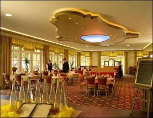a restaurant with tables and chairs and people in it at Land- und Kurhotel Tommes in Schmallenberg