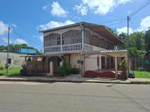 a house with a gate on the side of a street at Suite aconchegante do Tapana in Belém