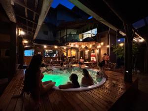 a group of people sitting in a swimming pool at night at Green Haven Hostel in Ubatuba +178 photos