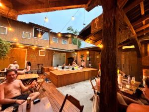 a group of people sitting at tables in a building at Green Haven Hostel in Ubatuba