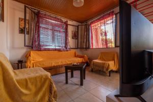 a living room with two beds and two windows at Patty's House Kallikratia in Vergia