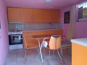 a kitchen with orange cabinets and a table and chairs at Patty's House Kallikratia in Vergia
