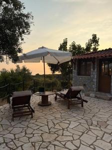 a patio with a table and an umbrella and chairs at Agnanti in Riglia