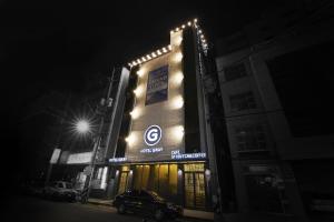 a building with a car parked in front of it at night at Hotel Gray in Busan
