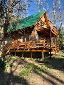 a large wooden cabin with a green roof at La Rubina in Villa Ventana