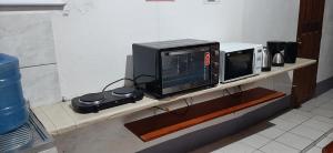 a microwave and a toaster oven on a counter at Suite aconchegante do Tapana in Belém