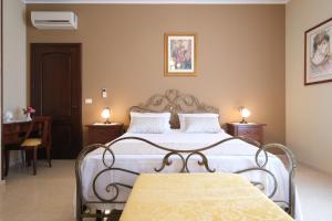 een slaapkamer met een bed en 2 tafels en een stoel bij B&B Borgosolare in Specchia