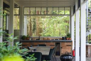 a kitchen with a table and a large window at Klein Nieuwe Wegen in Ons Belang