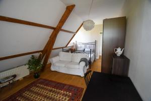 a living room with a white couch and a bed at Klein Nieuwe Wegen in Ons Belang