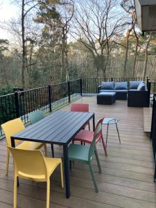 a wooden deck with a table and colorful chairs at Klein Nieuwe Wegen in Ons Belang