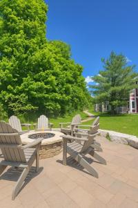 a patio with two chairs and a fire pit at Luxury Jacuzzi Suite with Sauna & Heated Pool in Shanty Bay