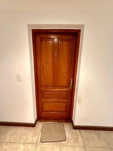 a wooden door in the corner of a room at Spacious Studio in Alsina in Salta +2 photos