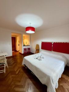 a bedroom with a large white bed with a red headboard at Spacious Studio in Alsina in Salta