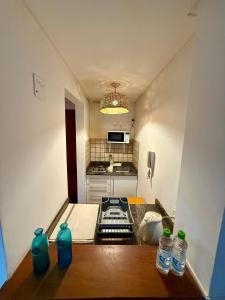 a small kitchen with a table with bottles on it at Spacious Studio in Alsina in Salta