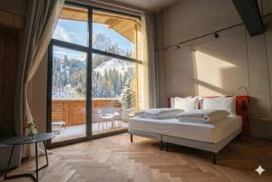 a bedroom with a bed and a large window at La Tambra - Hotel Lodge in Santa Cristina Gherdëina +71 photos