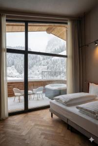 een slaapkamer met twee bedden en een groot raam bij La Tambra - Hotel Lodge in Santa Cristina in Val Gardena +77 foto's