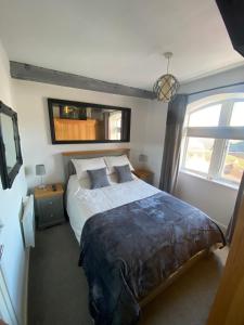 a bedroom with a large bed and a window at Comfortable Apartment set in an Old Mill in Westbury
